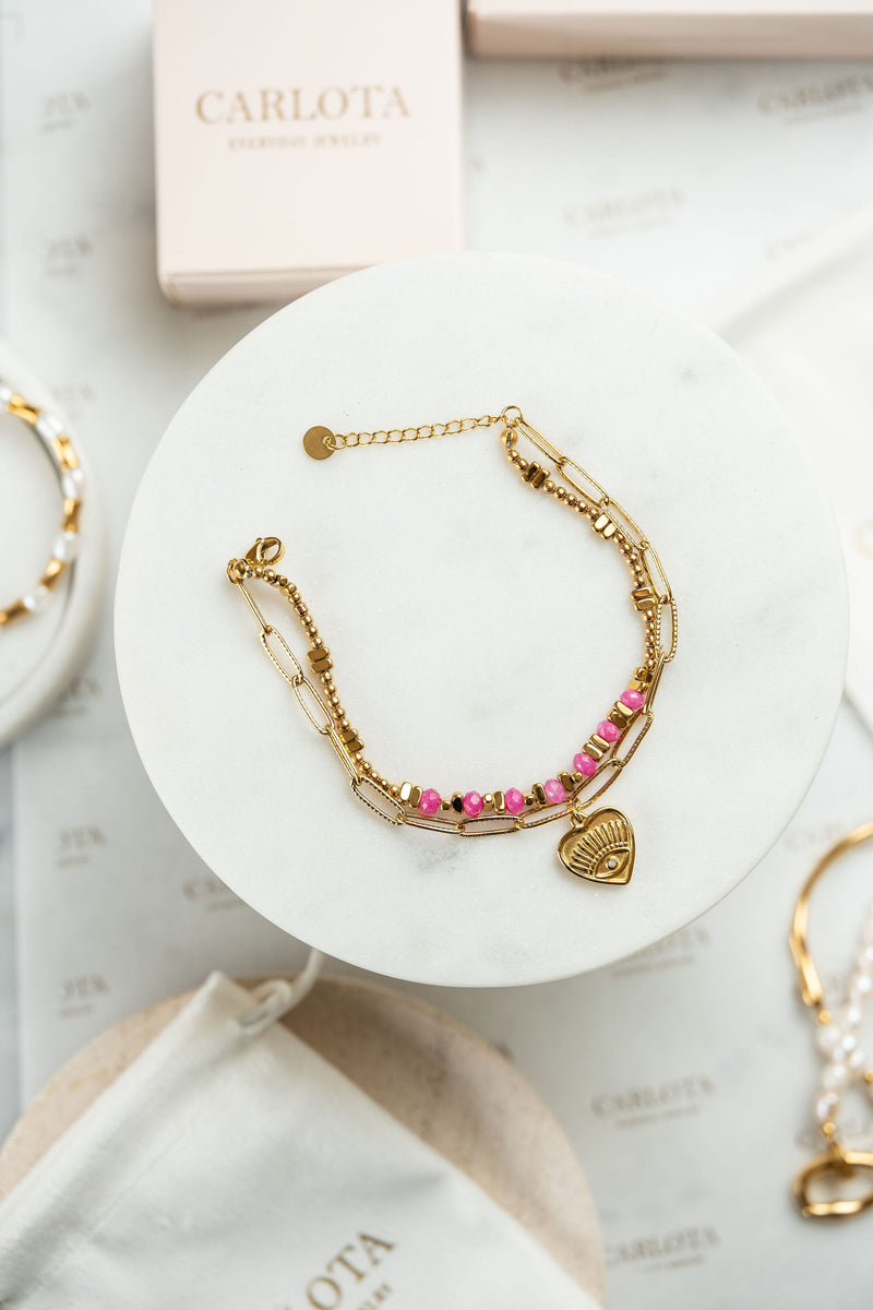 Pulsera doble de acero dorado y piedras en tonos rosa con dije corazón
