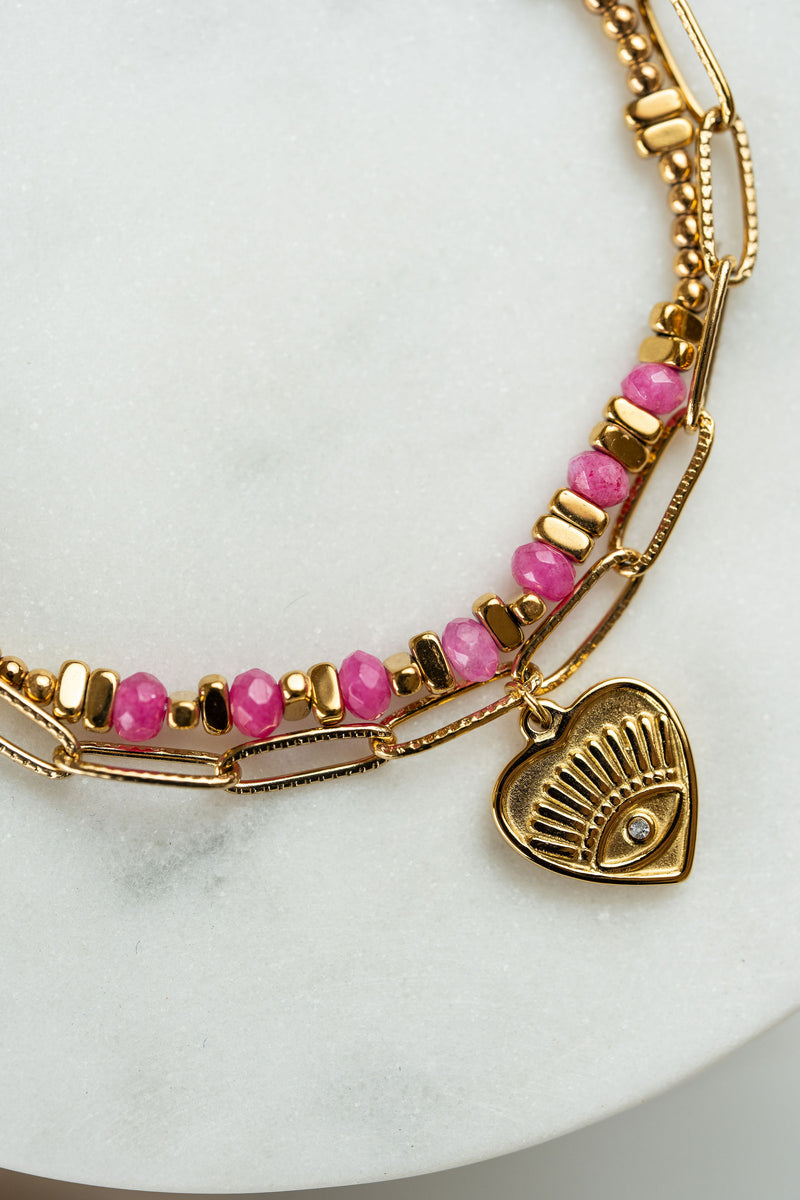 Pulsera doble de acero dorado y piedras en tonos rosa con dije corazón