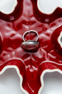 Anillo circular en acero quirúrgico CARLOTA en fondo rojo