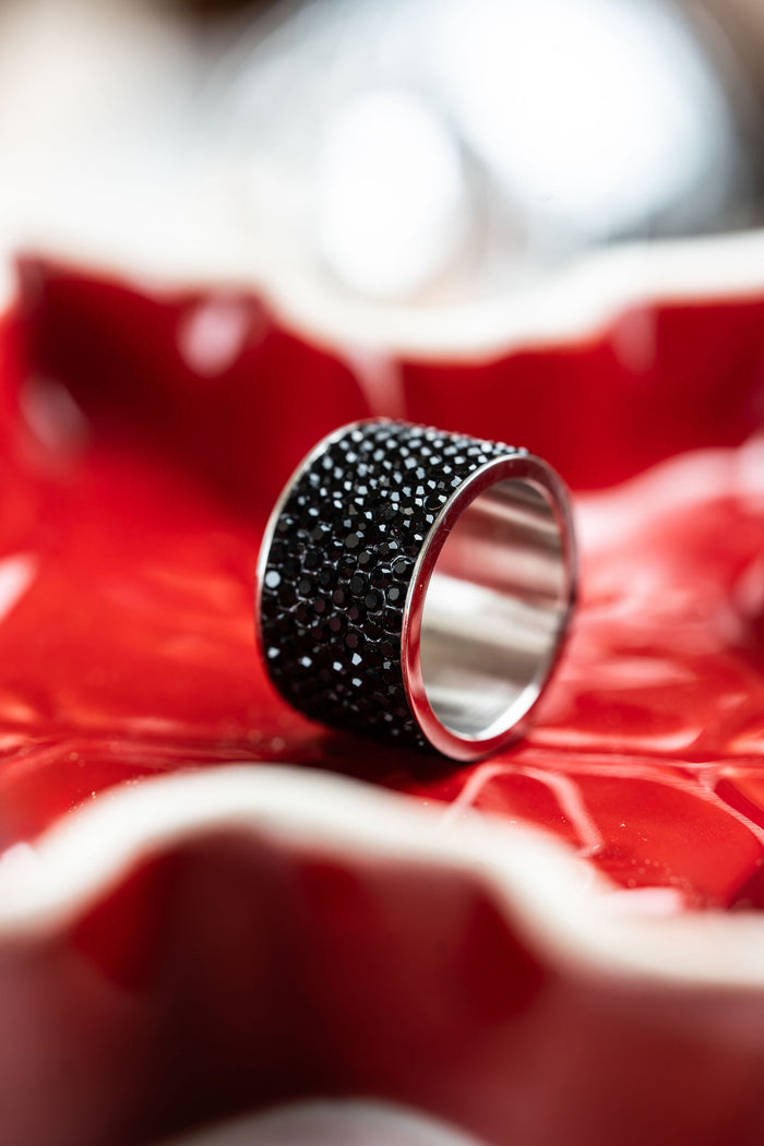Anillo de acero y brillos negros ancho en fono rojo, colección de CARLOTA