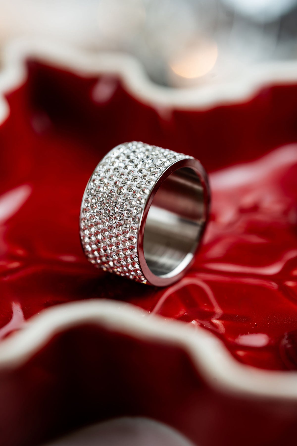 Anillo ancho de brillos plateado CARLOTA en fondo rojo