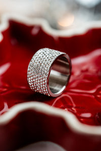 Anillo ancho de brillos plateado CARLOTA en fondo rojo