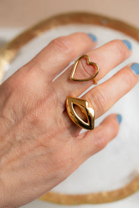 Anillos de acero dorado con forma de corazon y boca en mano CARLOTA