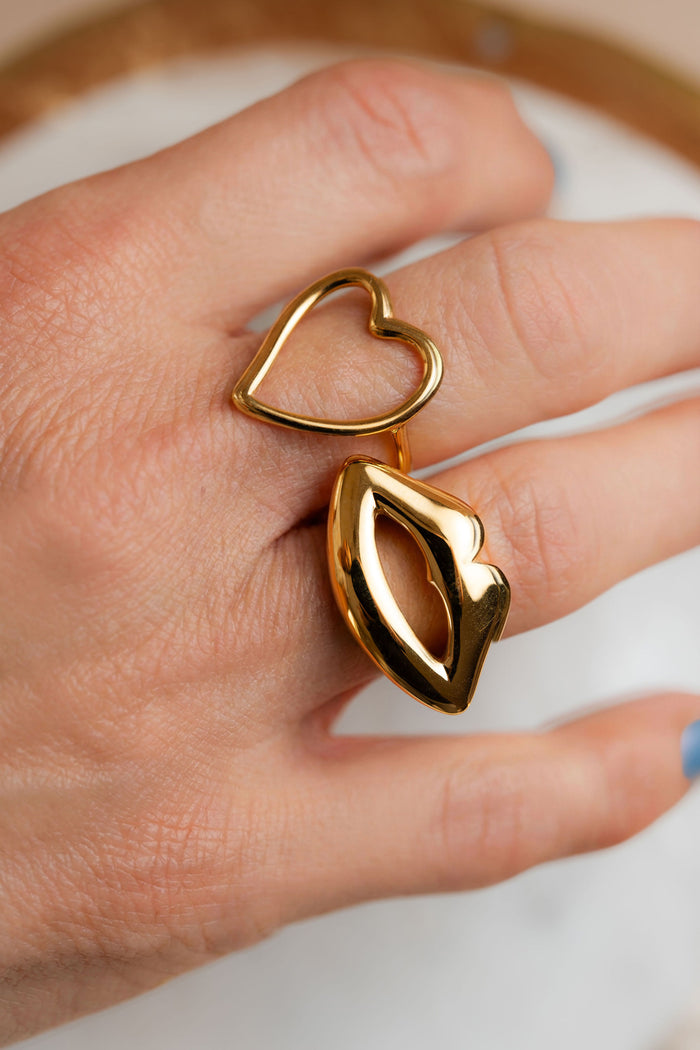 Anillos de acero dorado de CARLOTA con forma de corazón y boca en mano