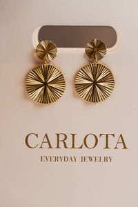 Aros dorados con argolla pequeña y dije circular con textura martillada, modelo Eloísa de CARLOTA.