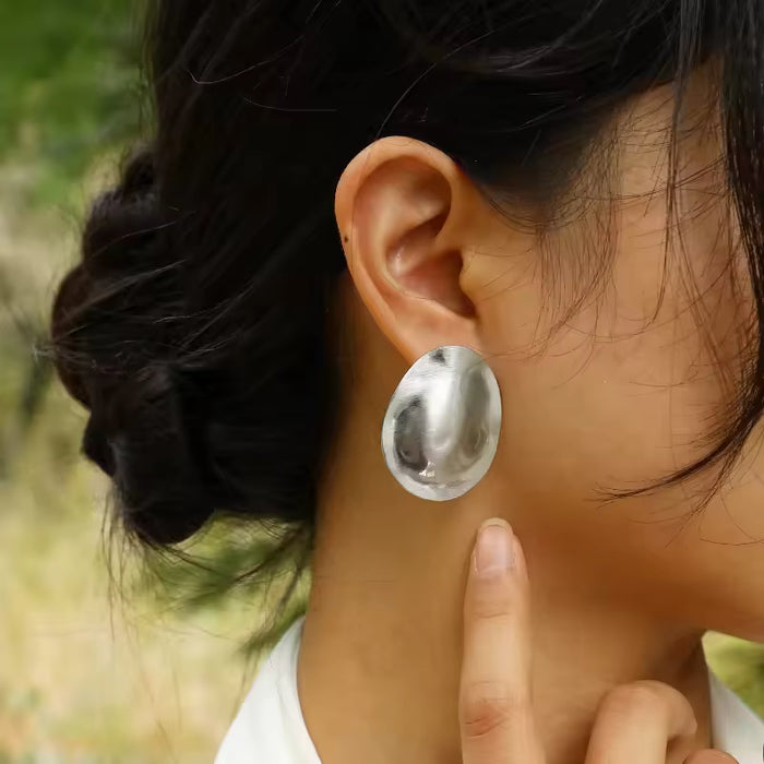 Aros plateados ovalados de acero quirúrgico en modelo