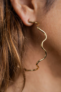 Aros ondulados en acero dorado en modelo
