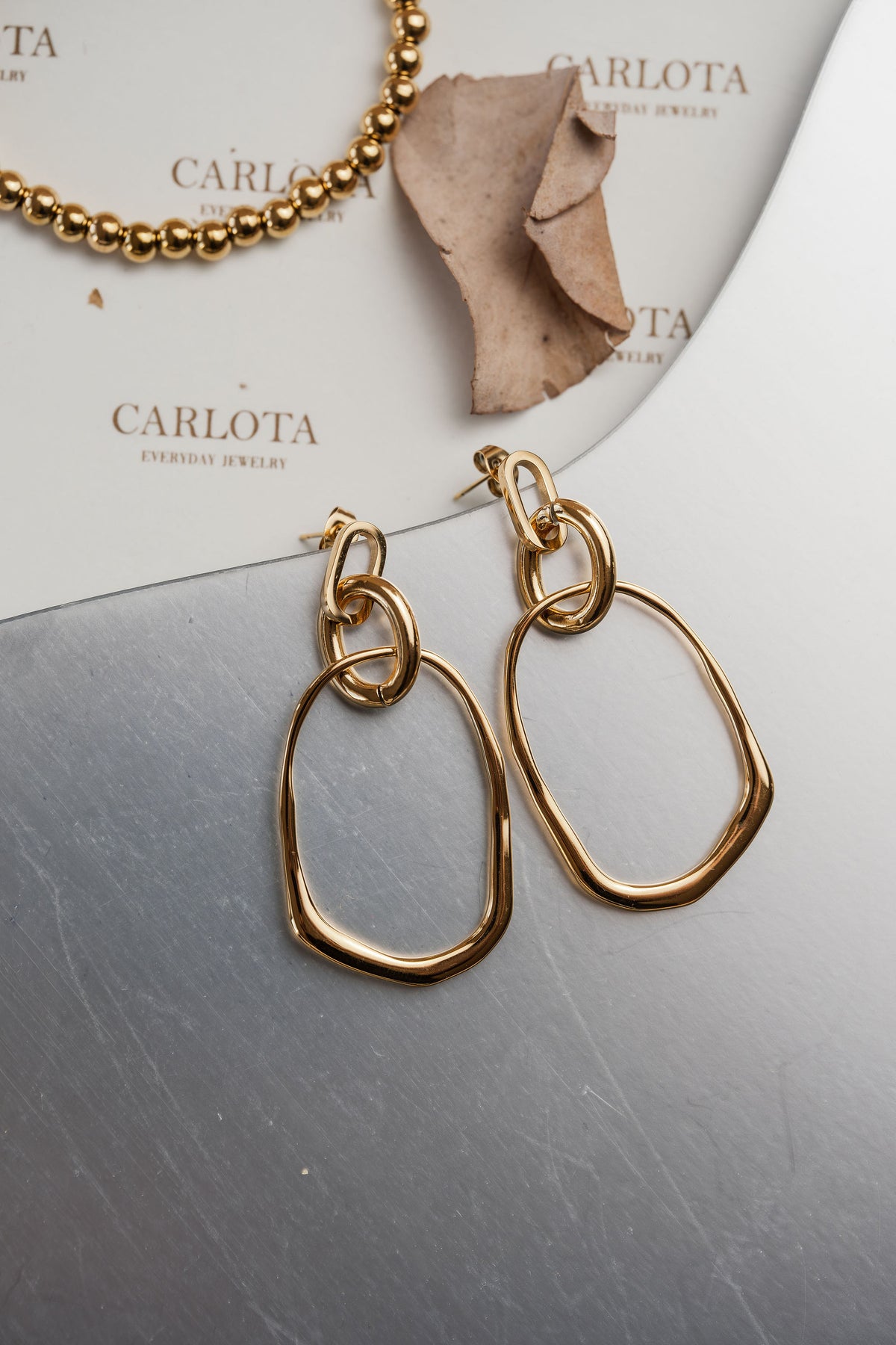 Aros dorados colgantes con diseño irregular orgánico, modelo Romi de CARLOTA.