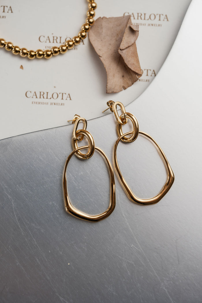 Aros dorados colgantes con diseño irregular orgánico, modelo Romi de CARLOTA.