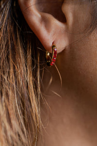 aros pequeños en acero dorado y circonias rojas en modelo