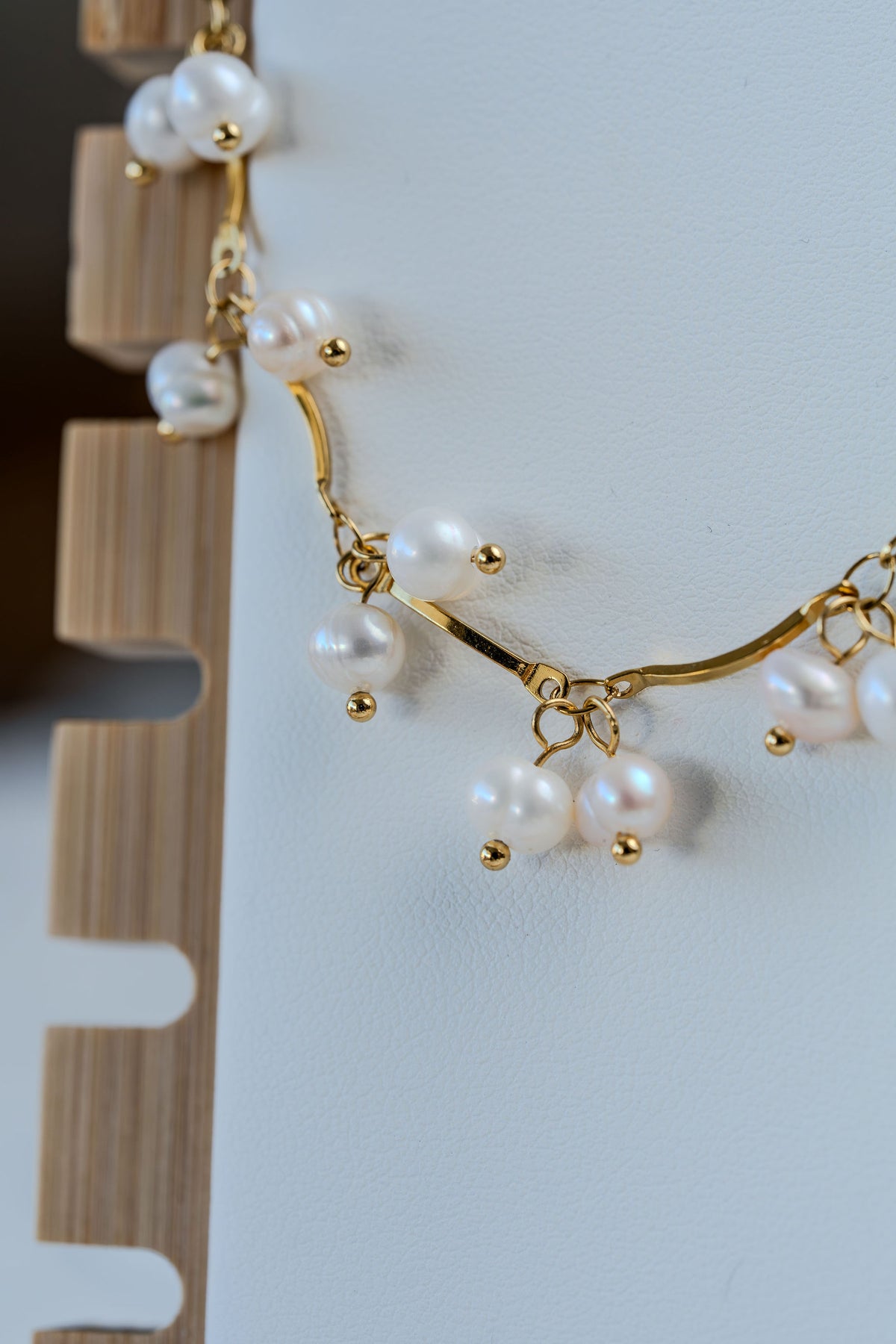 collar de acero dorado y perlas en detalle