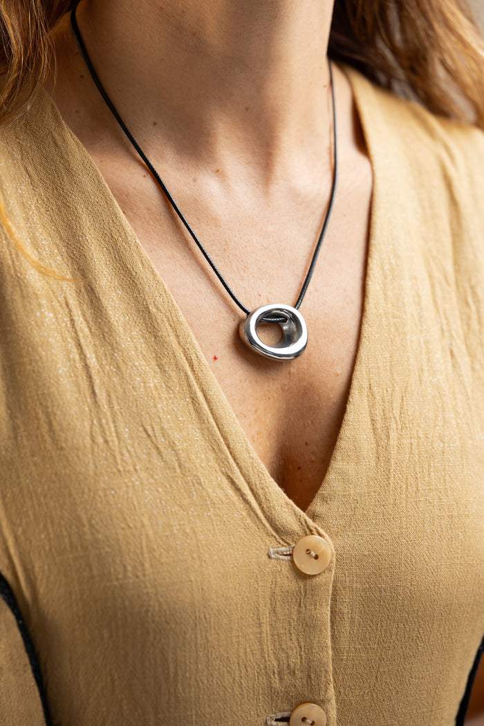 Collar cordón negro y dije metálico en modelo