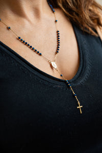 Collar Rosario en acero con baño de oro y cuentas azules brillantes con medalla de virgen y cruz en modelo. CARLOTA