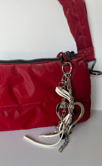 Llavero plateado con dije de corazón, cadenas decorativas y cinta blanca, diseño moderno CARLOTA en cartera ROJA