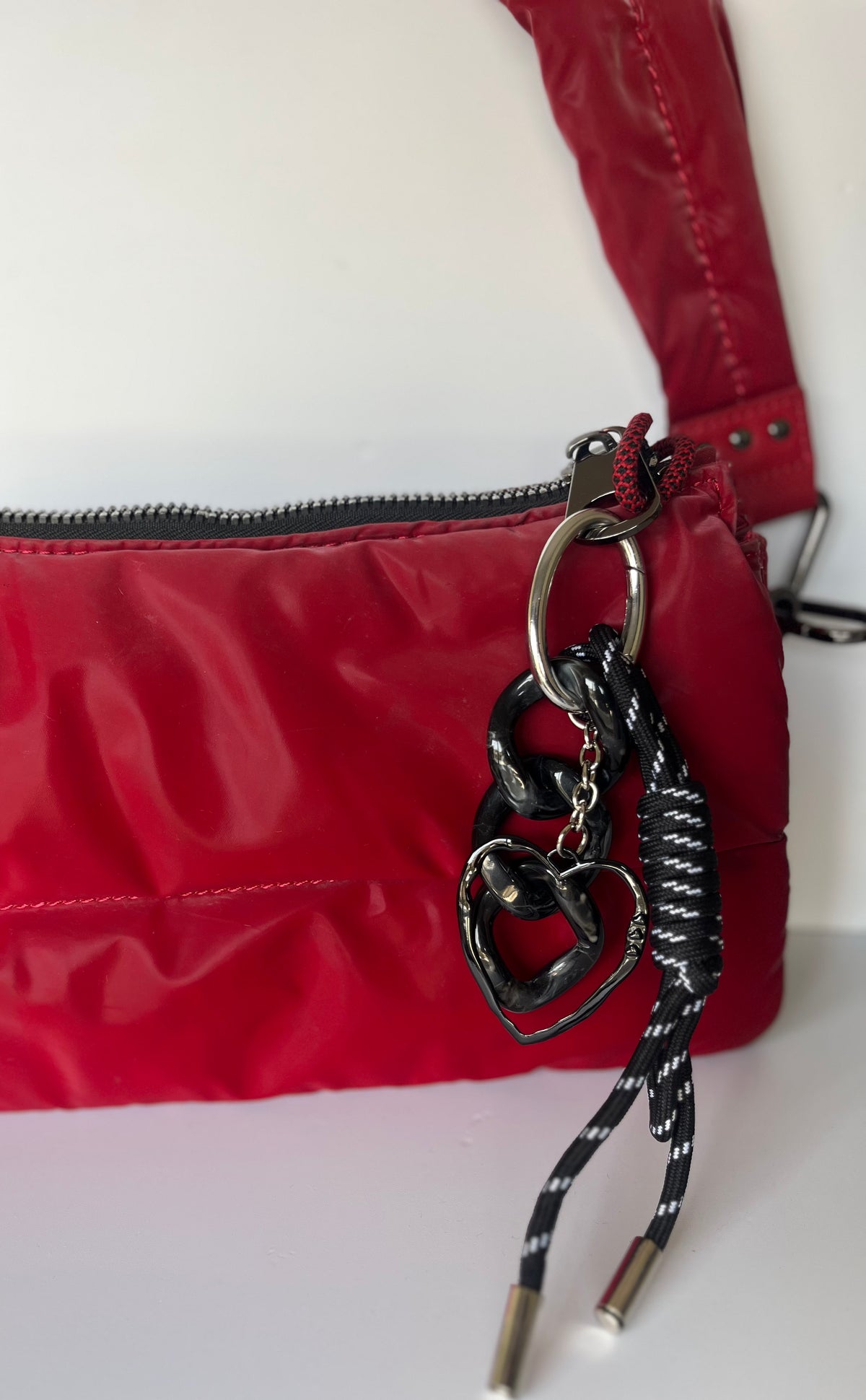 Llavero negro con cinta y dije de corazón en cartera roja