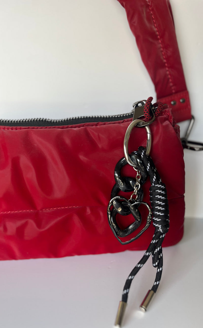 Llavero negro con cinta y dije de corazón en cartera roja