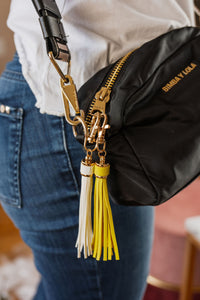 Llaveros de flecos en simil cuero amarillo y blanco en cartera negra