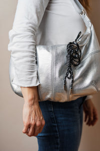Llavero negro con cordón y dije de corazón en cartera plateada. Ideal como accesorio para llaves, mochila o cartera.
