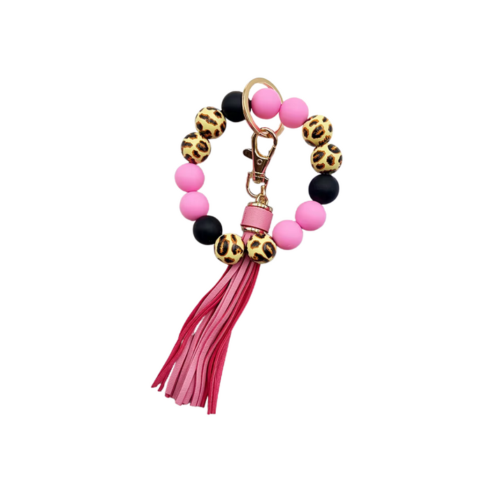 Llavero tipo pulsera con cuentas animal print, cuentas rosa y negras, y colgante de flecos en tonos rosa.
