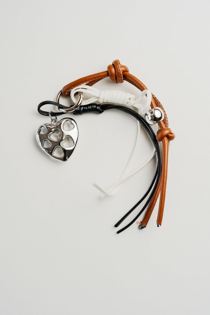 Llavero con dije de corazón plateado calado y cordones en tonos marrón, negro y blanco – CARLOTA.