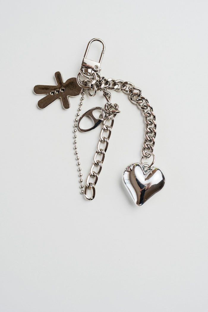 Llavero plateado con dije de corazón brillante, muñeco y cadenas – CARLOTA.
