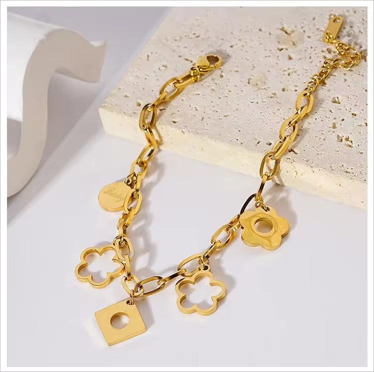 Pulsera en acero con dijes de flor con baño de oro