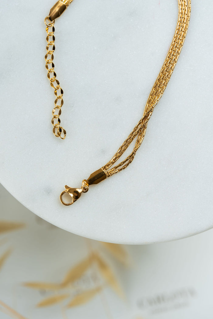 detalle de cierre de pulsera dorada de varias cadenas finas en acero quirúrgico