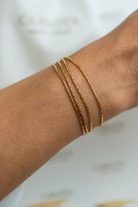 Pulsera dorada de varias cadenas finas en acero quirúrgico en mano