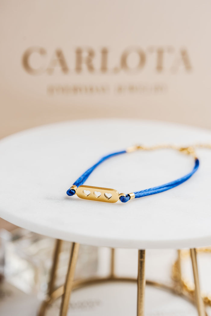 Pulsera con hilo azul y piezas doradas, estilo minimalista y ajustable, modelo Love Blue de CARLOTA.