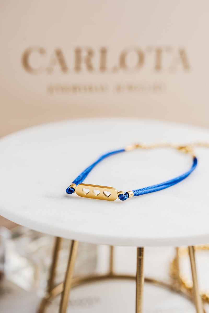 Pulsera con hilo azul y piezas doradas, estilo minimalista y ajustable, modelo Love Blue de CARLOTA.