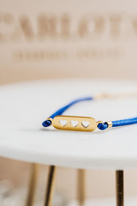 Pulsera con hilo azul y piezas doradas, estilo minimalista y ajustable, modelo Love Blue de CARLOTA.