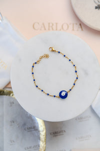 Pulsera de acero dorado y borlas azules con ojo turco