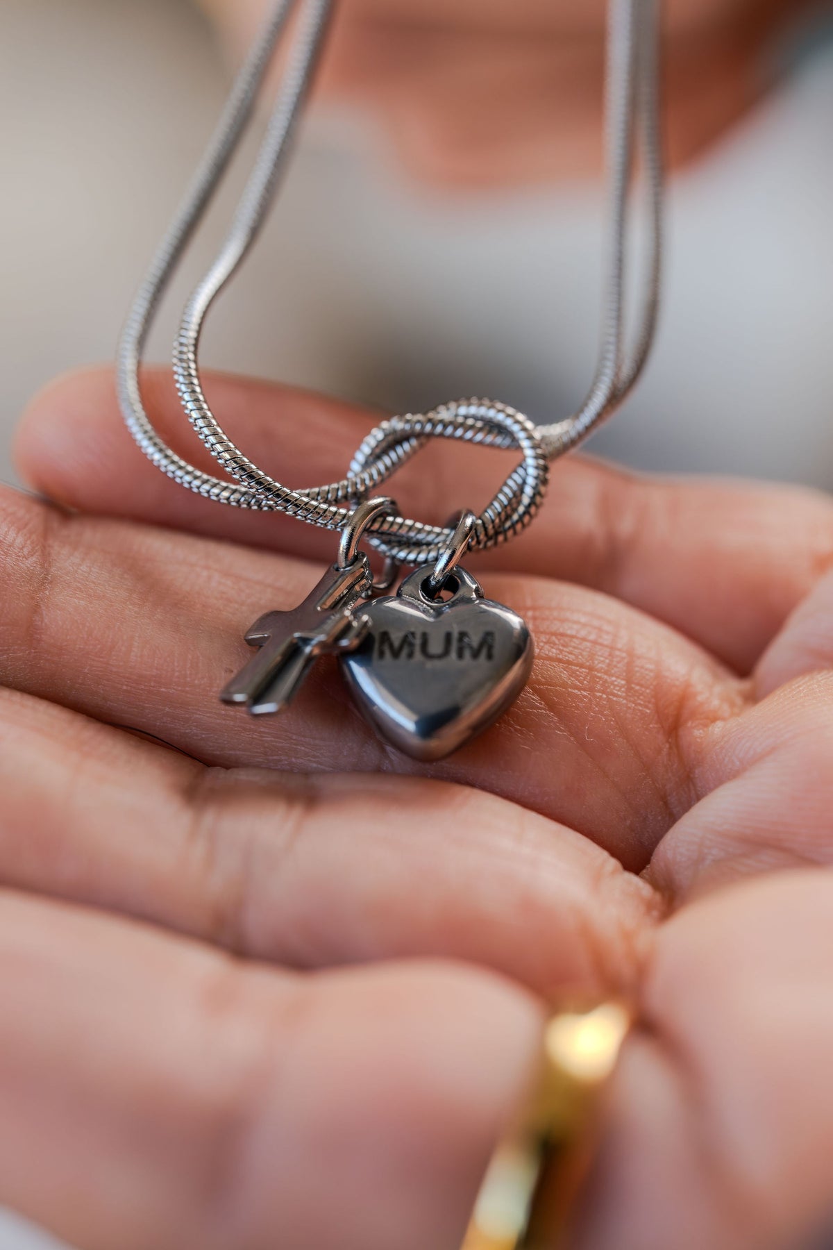 Pulsera de acero con dijes corazon y cruz