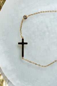 Tobillera dorada con cruz en acero quirúrgico y punto luz de CARLOTA