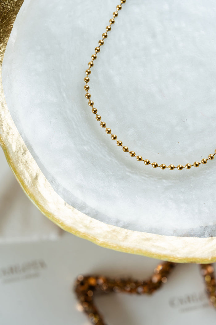 Tobillera dorada de bolitas en acero quirúrgico.