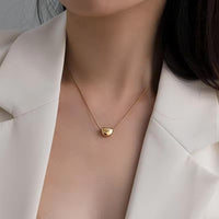 Mujer con collar de acero quirúrgico y dije dorado de diseño minimalista