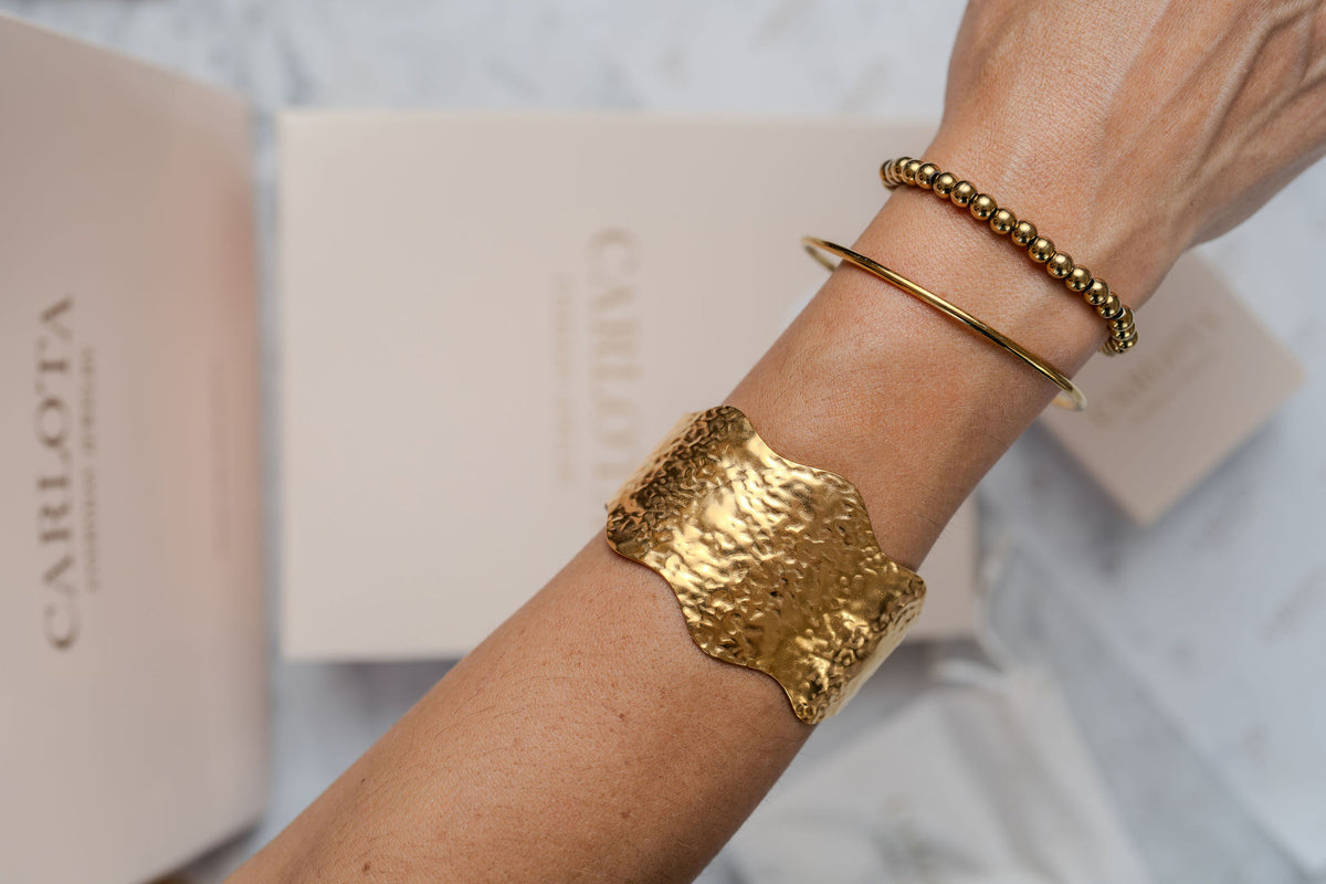 Pulseras de acero =y baño de oro en brazo de modelo de CARLOTA
