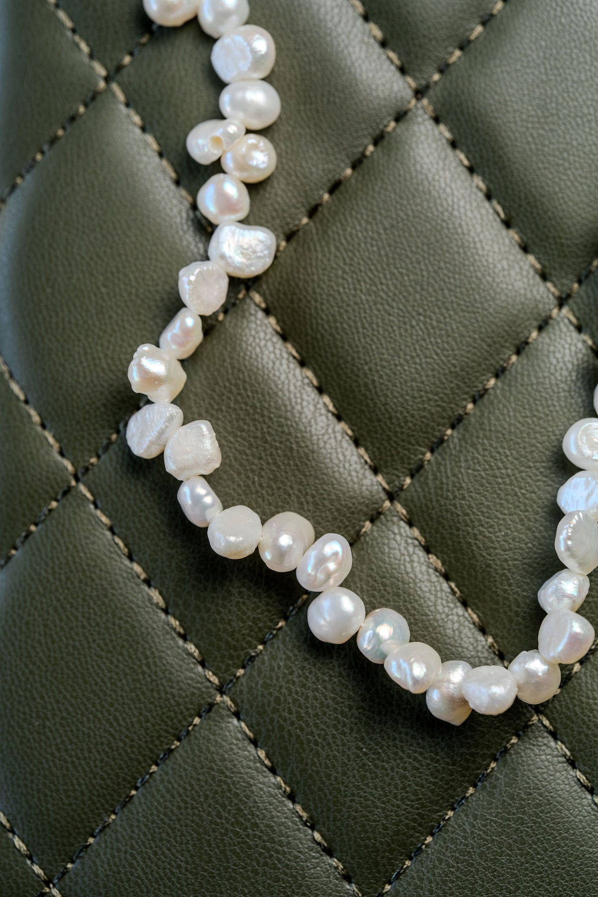 Collar de perlas naturales sobre fondo verde
