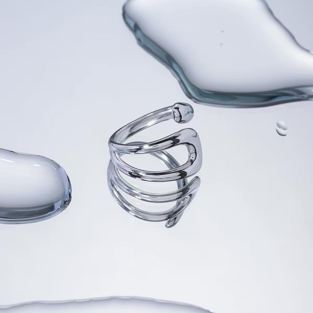 Anillo Praia de acero quirúrgico con diseño abierto y forma curva orgánica.
